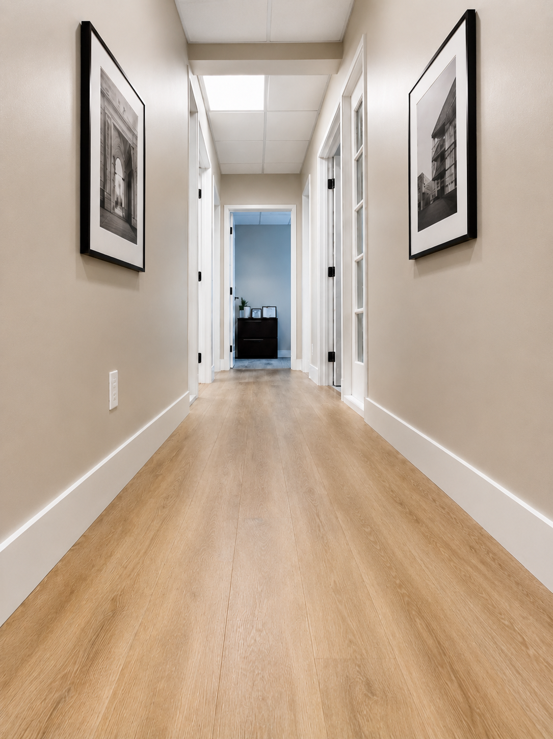 Hallway transition from wood flooring to carpet with glass-panel office door