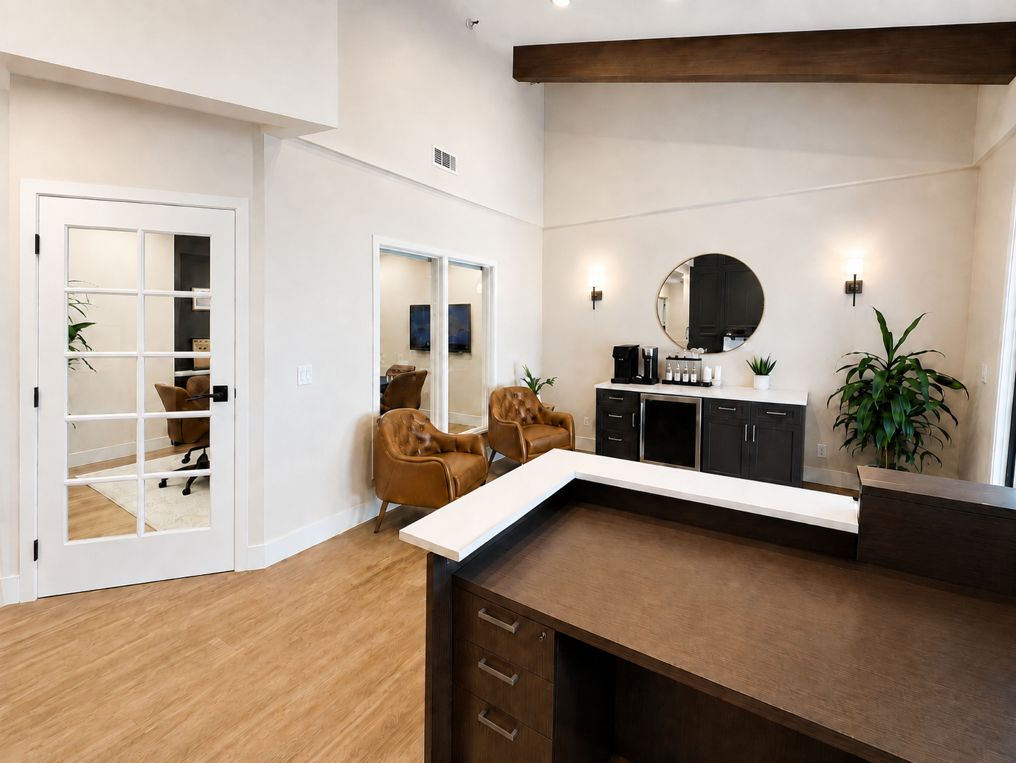 Lobby overview with reception desk, beverage station, and French doors